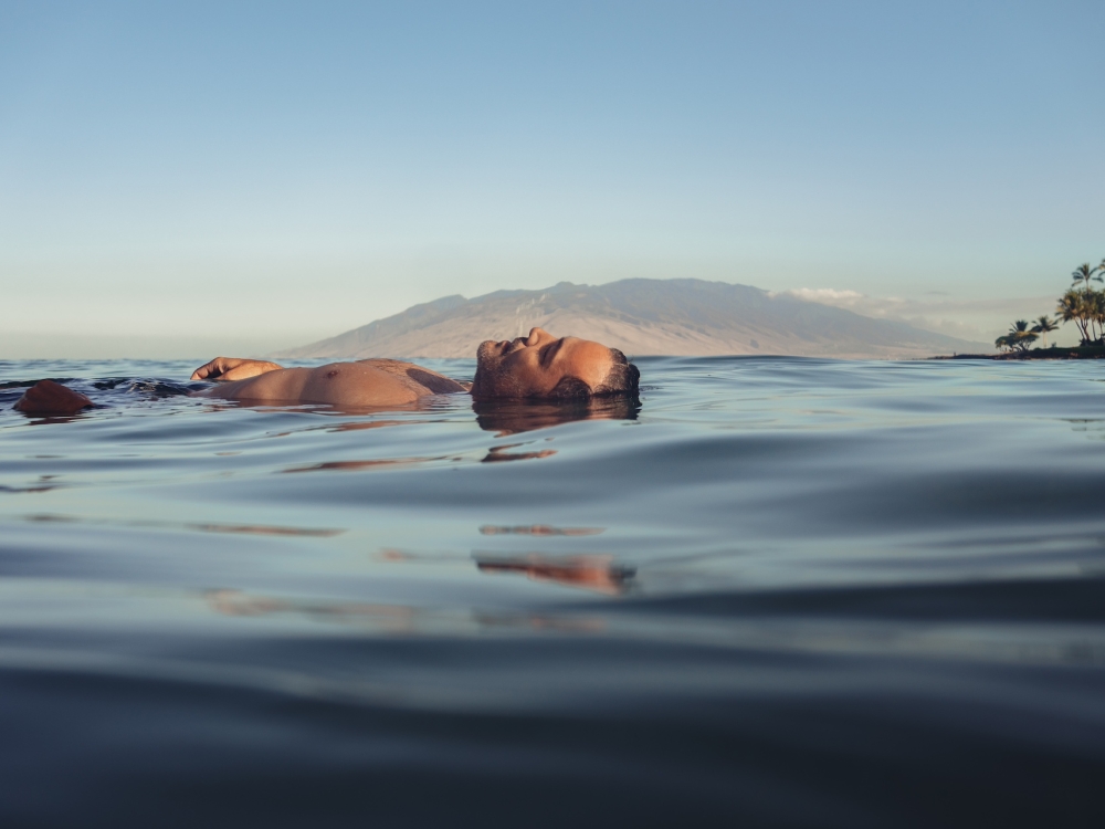 A man floats on his back in the sea