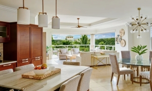 An open resort villa kitchen, in view of a dining area and balcony